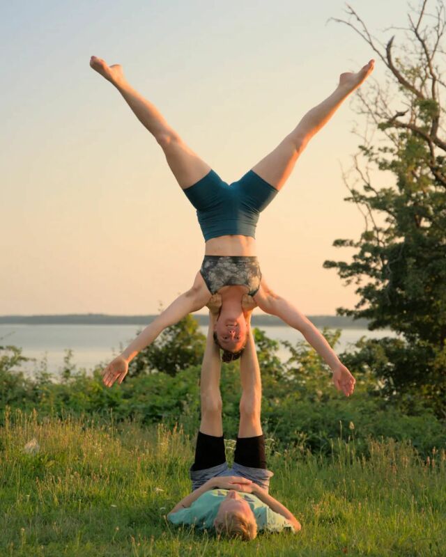 Man and two women practicing acro yoga in group Stock Photo by vadymvdrobot
